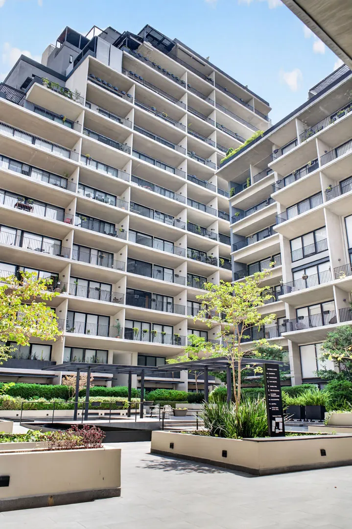 Fotografía de arquitectura del patio interior de una torre residencial con balcones y jardines